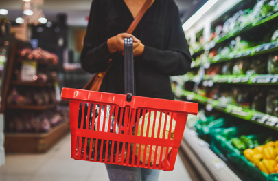 Person holding shopping basket in supermarket